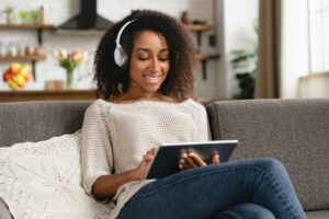 Girl using tablet, watching online webinar, listening to the music playlist radio e-book podcast